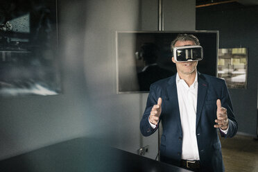 Reifer Geschäftsmann mit VR-Brille im Büro - JOSF02239