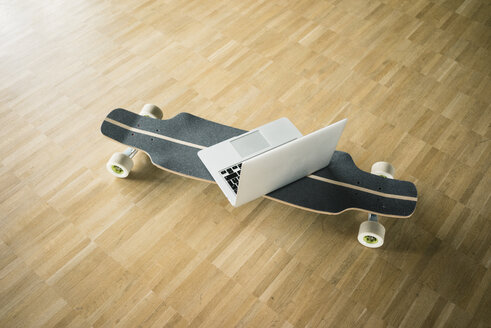 Laptop and longboard on wooden floor - JOSF02272