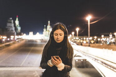 Russland, Moskau, schöne Frau hört Musik in der Stadt bei Nacht - WPEF00350