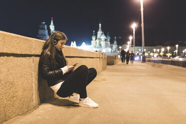 Russland, Moskau, schöne Frau hört Musik in der Stadt bei Nacht - WPEF00351