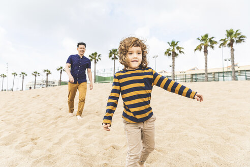 Spain, Barcelona, father and son walking on the beach - WPEF00356