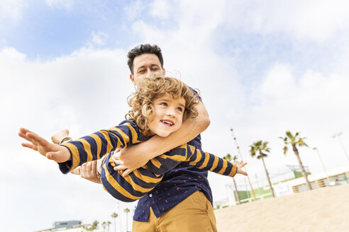 Spain, Barcelona, father and son playing on the beach - WPEF00358