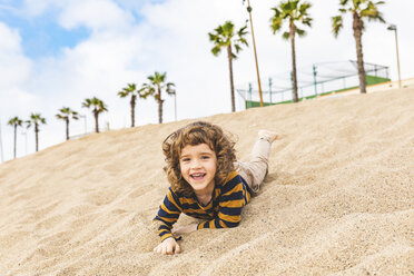 Spain, Barcelona, boy having fun in the sand on the beach - WPEF00361