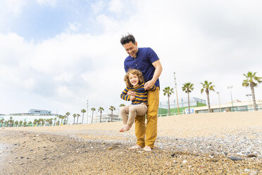Spanien, Barcelona, Vater hält seinen Sohn am Strand - WPEF00365