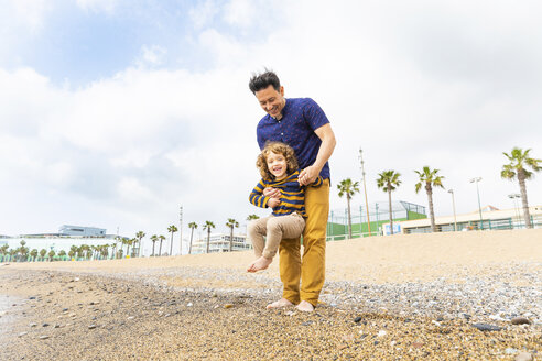 Spain, Barcelona, father holding his son on the beach - WPEF00365