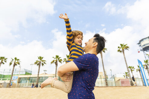 Spain, Barcelona, happy father and son on the beach - WPEF00374