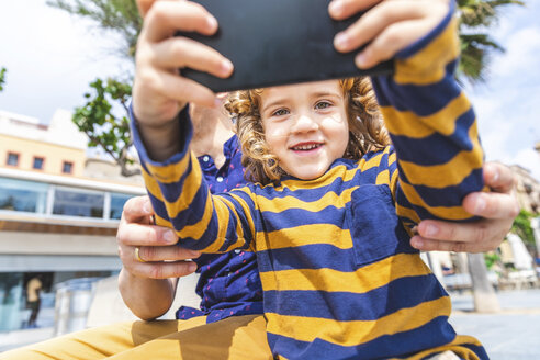 Spain, Barcelona, father and son taking a selfie with a smartphone - WPEF00378