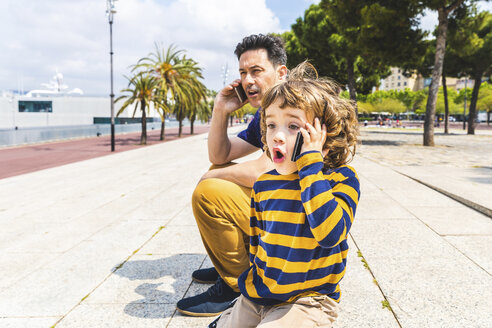 Spain, Barcelona, father and son both with a smartphone - WPEF00382