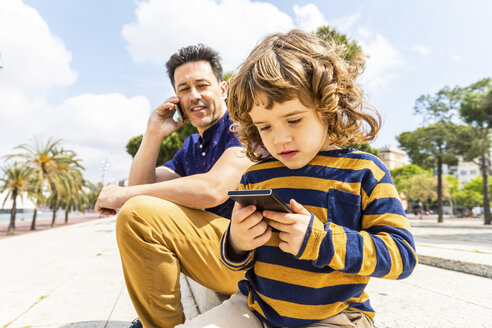 Spain, Barcelona, father and son both with a smartphone - WPEF00383