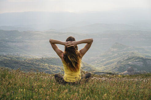 Spain, Barcelona, back view of young woman relaxing on Montcau Mountain - AFVF00541