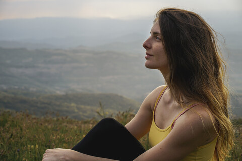 Spanien, Barcelona, Porträt einer jungen Frau beim Entspannen auf dem Berg Montcau, lizenzfreies Stockfoto