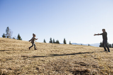 Female toddler running to father on hill, Tegernsee, Bavaria, Germany - CUF15111