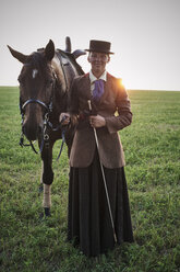 Porträt einer Frau mit Dressurpferd auf einem Feld - CUF15141