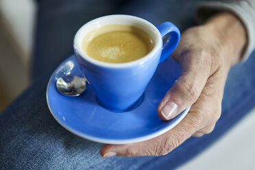 Hand hält Untertasse mit Tasse Kaffee - CUF15148