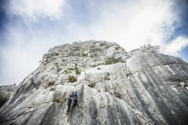 Tiefblick von hinten auf einen Kletterer, der einen Berghang hinaufklettert, Ogliastra, Sardinien, Italien - CUF15171