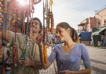Junges Paar auf dem Markt, das sich Perlen ansieht, Jemaa el-Fnaa-Platz, Marrakesch, Marokko - CUF15381