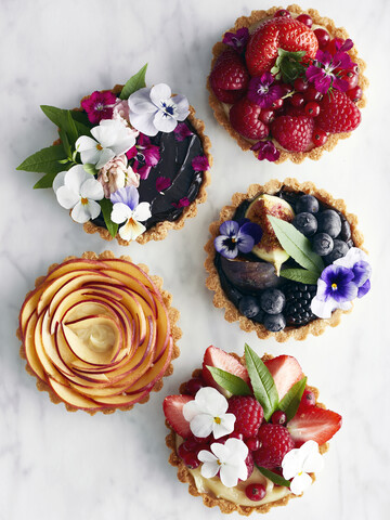 Auslage mit verschiedenen Torten, Früchten und Blumen, lizenzfreies Stockfoto