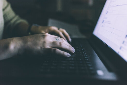 Hand einer jungen Frau, die auf einem Laptop tippt - CUF15668