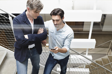 Colleagues on stairway looking at smartphone - CUF15751