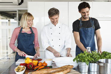 Koch und Ehepaar in der Küche beim Schneiden von Gemüse - CUF15773