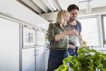 Couple in kitchen cooking pasta - CUF15780