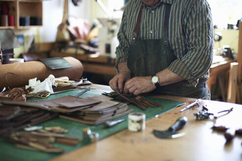 Männlicher Arbeiter in einer Lederwerkstatt, der Leder zurechtlegt, Mittelteil - CUF15832