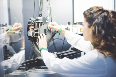 Wissenschaftlerin beim Positionieren einer Dünnschichtprobe auf einem Probenhalter am Röntgendiffraktometer - CUF15907