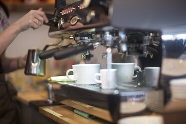 Cropped shot of waitress's using coffee machine in cafe - CUF15947