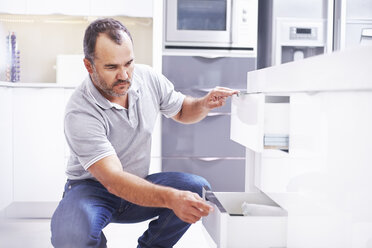 Joiner installing drawers in kitchen - CUF15949