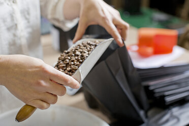 Kaffeeverkäufer füllt Tasche mit Kaffeebohnen - CUF15970