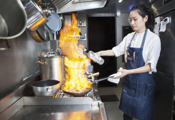 Chef flambeing in commercial kitchen - CUF16030