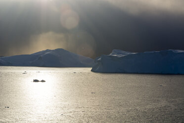 Storm clouds and sunlight over icebergs in Ilulissat icefjord, Disko Bay, Greenland - CUF16113