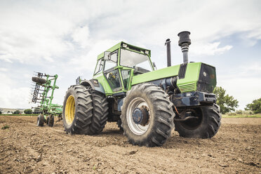 Landwirt fährt Traktor und Pflug auf einem gepflügten Feld - CUF16172