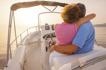 Romantic mature couple driving speedboat at sunset, Majorca, Spain - CUF16177