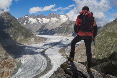 Rear view of lone male climber looking out over Aletsch Glacier, Canton Wallis, Switzerland - CUF16287