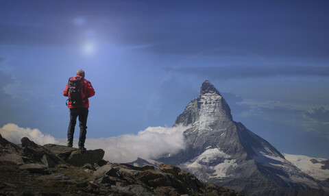 Rückansicht eines älteren männlichen Bergsteigers mit Blick auf das Matterhorn, Kanton Wallis, Schweiz, lizenzfreies Stockfoto