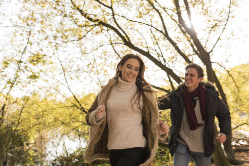 Junges Paar läuft lachend im Wald - CUF16303