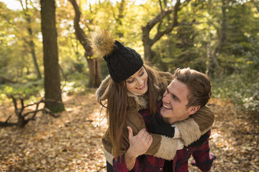 Junges Paar im Wald, junger Mann nimmt junge Frau Huckepack, lachend - CUF16304