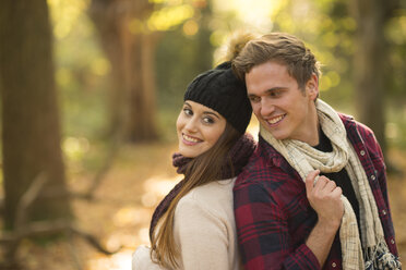 Young couple in forest, back to back, smiling - CUF16320