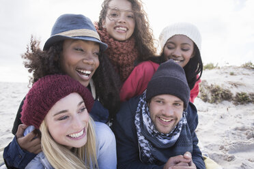 Portrait of young adult friends lying on top of each other on beach, Western Cape, South Africa - CUF16348