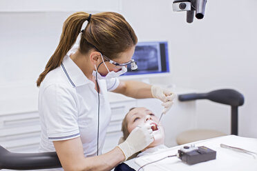Zahnarzt in einer Zahnklinik bei der zahnärztlichen Untersuchung einer jungen Frau - CUF16469
