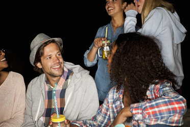 Group of friends holding mason jars chatting and smiling - CUF16509