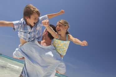 Mittelgroßer Mann mit Sohn und Tochter auf dem Arm am Strand, Mallorca, Spanien - CUF16536