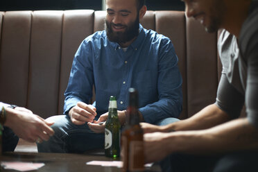 Drei männliche Freunde spielen Karten in einem traditionellen britischen Pub - CUF16684