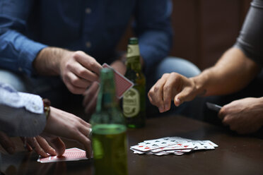 Hands of three men playing card game in traditional UK pub - CUF16687