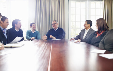 Colleagues in conference room sitting at table having a meeting - CUF16743