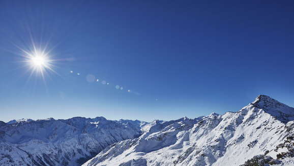 Erhöhter Blick auf Sonnenlicht und blauen Himmel über schneebedeckten Bergen, Gaislachkogel, Sölden, Tirol, Österreich - CUF16823