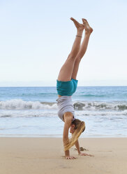 Young woman doing handstand on beach, Dominican Republic, The Caribbean - CUF17191