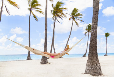 Junge Frau in Palmen-Hängematte am Strand liegend, Dominikanische Republik, Karibik - CUF17201