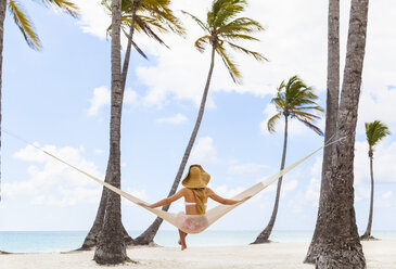 Rear view of young woman sitting on beach hammock, Dominican Republic, The Caribbean - CUF17202